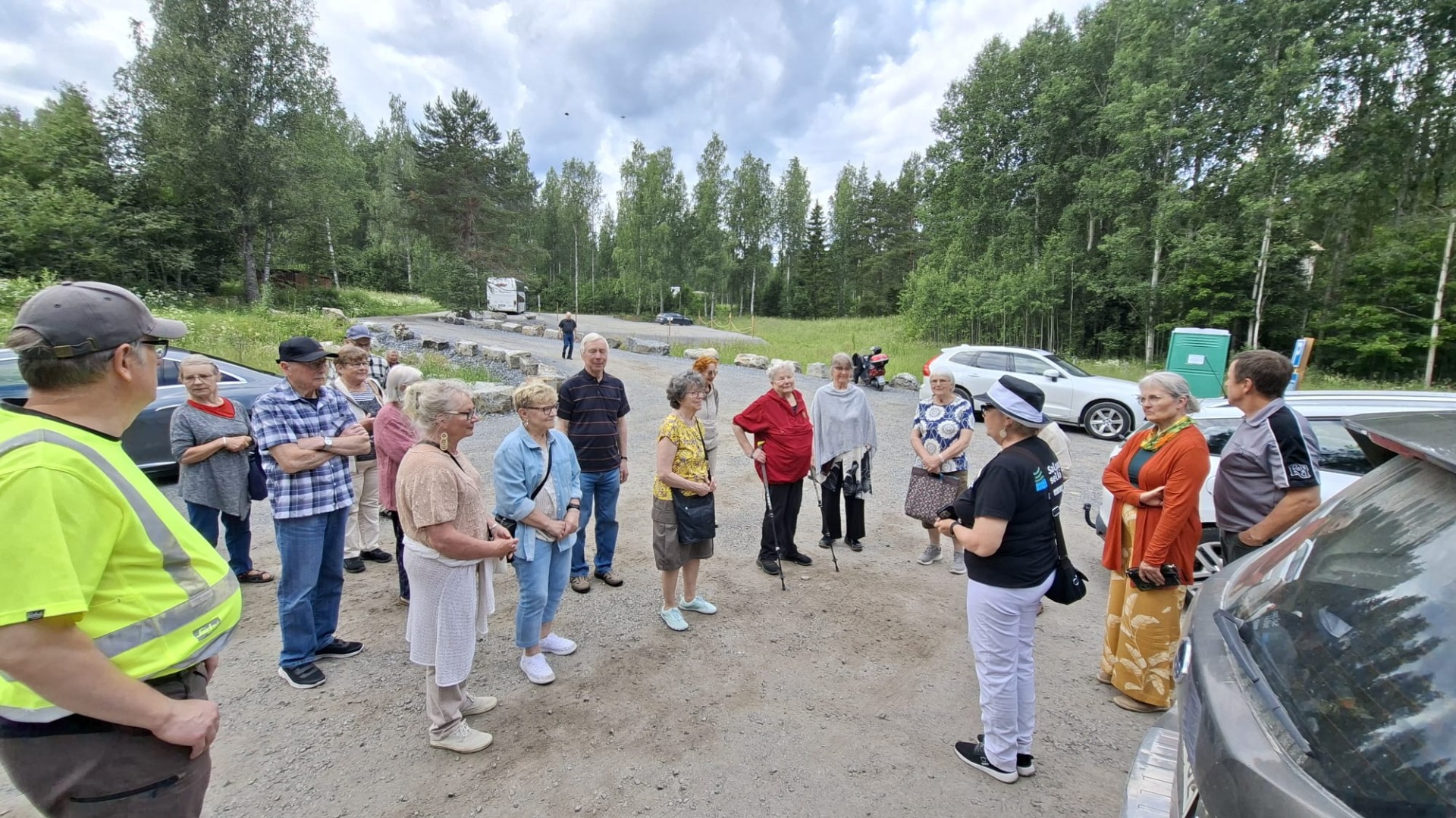 Joukko ihmisiä kesäisessä maisemassa.